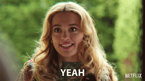 A Woman Is Smiling And Says Yeah In Front Of A Green Background GIF