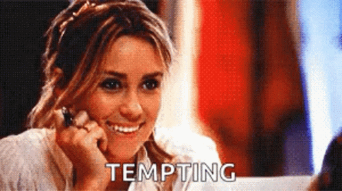 A Woman Is Smiling And The Word Tempting Is On The Screen GIF