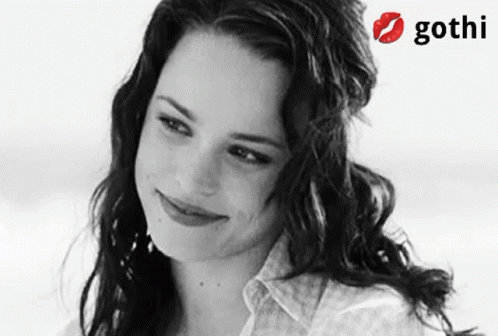 A Woman Is Smiling In A Black And White Photo With A Gothi Logo Behind Her GIF