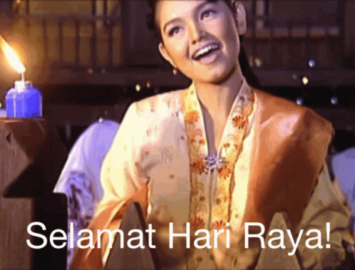 A Woman Is Smiling In Front Of A Candle And The Words Selamat Hari Raya GIF