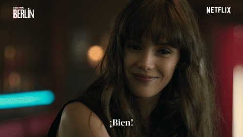 A Woman Is Smiling In Front Of A Netflix Banner GIF