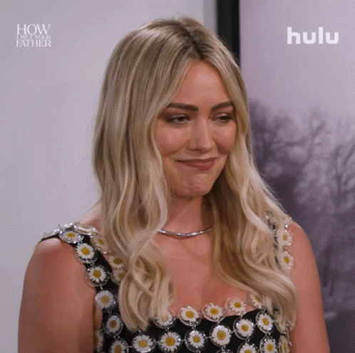 A Woman Is Smiling In Front Of A Picture That Says How I Met Your Father GIF