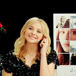 A Woman Is Smiling In Front Of A Poster For If GIF