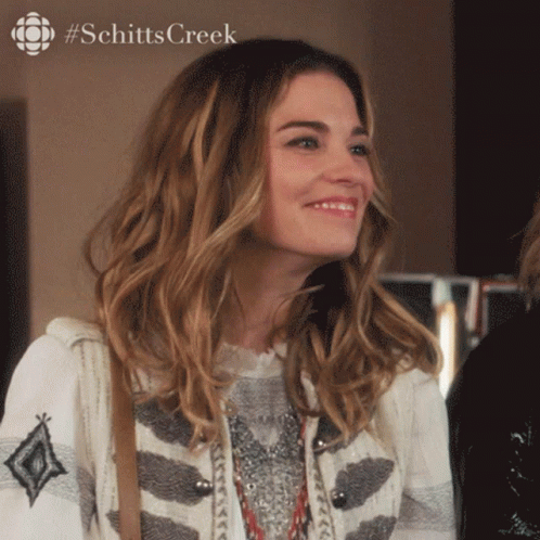 Woman Smiling In Front Of #Schittscreek Ad GIF