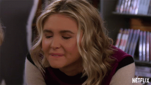 Woman Smiling In Front Of Netflix Shelf GIF