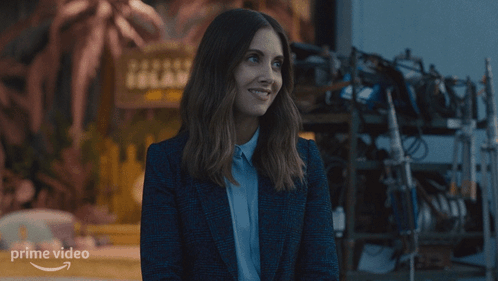 a woman is smiling in front of a sign for prime video