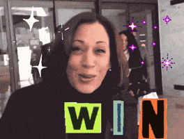 A Woman Is Smiling In Front Of A Sign That Reads Win GIF