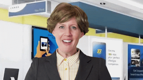 A Woman Is Smiling In Front Of A Sign That Says Cards GIF
