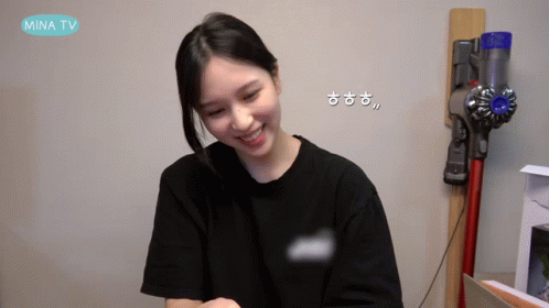 A Woman Is Smiling In Front Of A Vacuum Cleaner That Says Mina Tv On The Bottom GIF