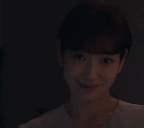 a woman is smiling while holding a knife with a purple light on it