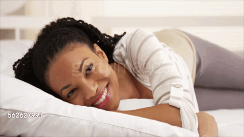 A Woman Is Smiling While Laying On A Bed With The Number 562627991 On The Bottom GIF