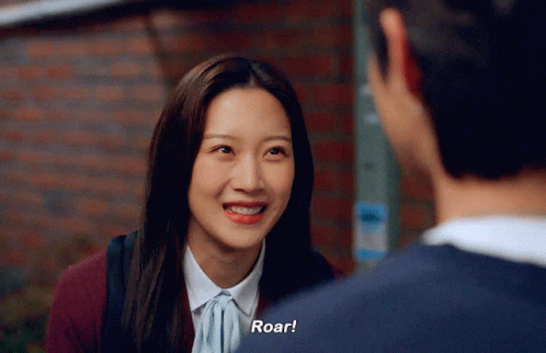 A Woman Is Smiling While Talking To A Man And Says Roar GIF