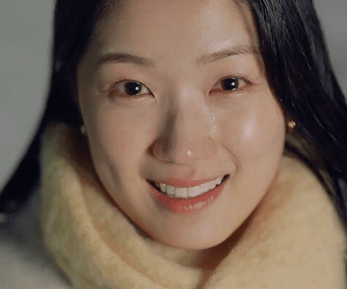 A Woman Is Smiling With A Tear Running Down Her Cheek GIF