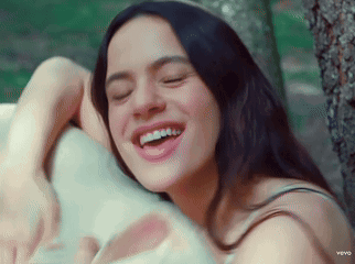 A Woman Is Smiling With Her Eyes Closed And Her Teeth Showing GIF