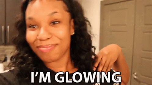 A Woman Is Smiling With The Words I 'M Glowing Below Her GIF