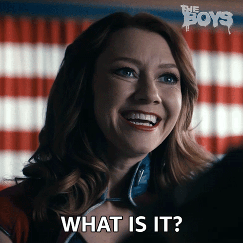 A Woman Is Smiling With The Words What Is It Behind Her GIF