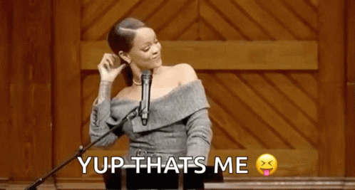 A Woman Is Standing At A Podium In Front Of A Microphone And Saying Yup Thats Me . GIF