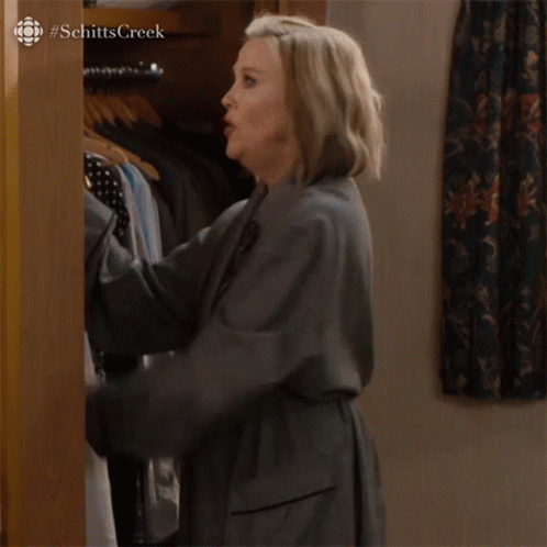 A Woman Is Standing In A Closet And Saying I 'M Building A Mystery GIF