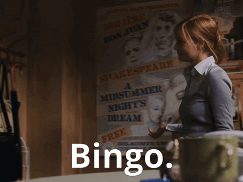 A Woman Is Standing In A Dark Room And The Word Bingo Is On The Screen GIF