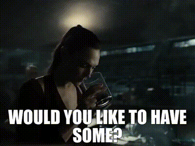 A Woman Is Standing In A Dark Room With The Words `` Would You Like To Have Some '' Written Above Her . GIF