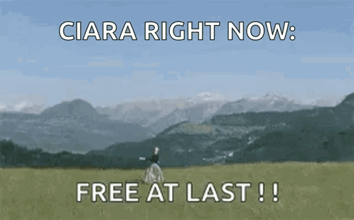 A Woman Is Standing In A Field With Mountains In The Background And The Words " Free At Last " GIF
