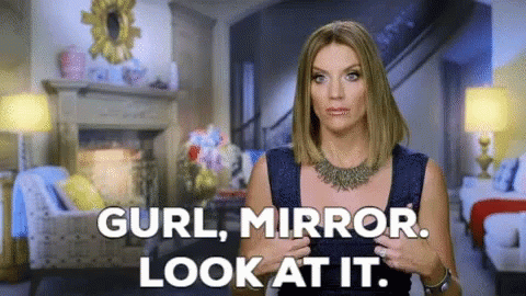 A Woman Is Standing In A Living Room With The Words " Curl Mirror Look At It " GIF