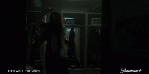 A Woman Is Standing In A Locker Room With The Words Teen Wolf The Movie On The Bottom GIF