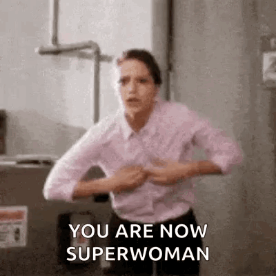 A Woman Is Standing In A Room With Her Hands On Her Chest . GIF