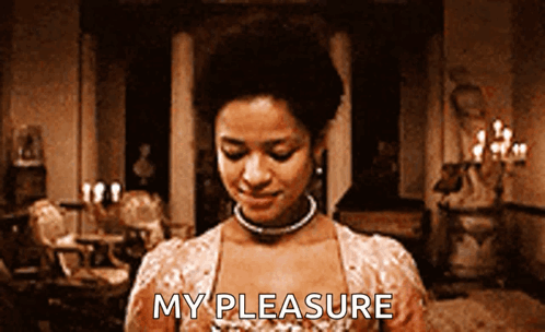 A Woman Is Standing In A Room With The Words My Pleasure Written On Her Chest GIF