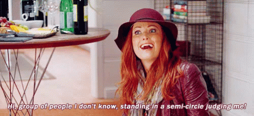A Woman Is Standing In A Semi-Circle Judging Another Woman . GIF