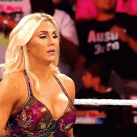 a woman is standing in a wrestling ring wearing a very revealing dress .