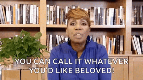 A Woman Is Standing In Front Of A Bookshelf And Saying `` You Can Call It Whatever You 'D Like Beloved ! '' GIF