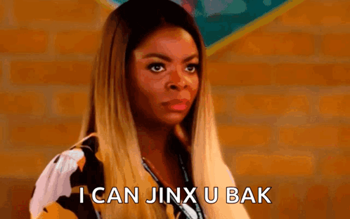 A Woman Is Standing In Front Of A Brick Wall And Says `` I Can Jinx U Bak '' . GIF