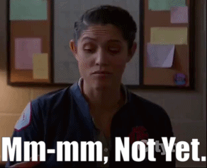 A Woman Is Standing In Front Of A Bulletin Board And Says Mm-Mm Not Yet . GIF
