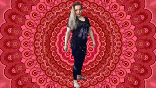 A Woman Is Standing In Front Of A Circular Pattern GIF