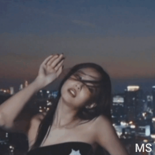 A Woman Is Standing In Front Of A City Skyline With The Letters Ms On The Bottom Right GIF