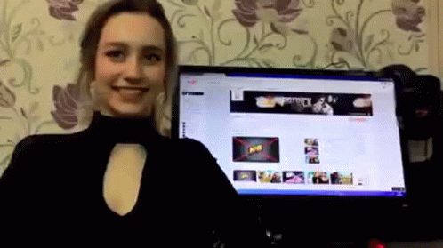 A Woman Is Standing In Front Of A Computer Monitor With A Banner On The Screen That Says " Army " GIF