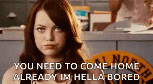 A Woman Is Standing In Front Of A Counter And Talking To Someone . GIF