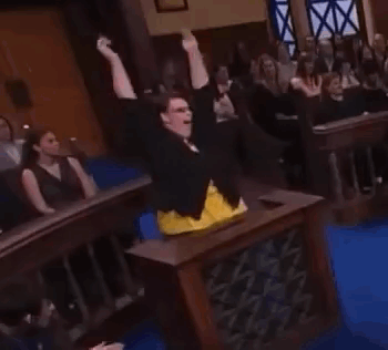 a woman is standing in front of a crowd in a courtroom .