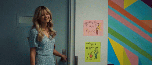 A Woman Is Standing In Front Of A Door That Has A Sign On It That Says Microsoft Love Kyle GIF