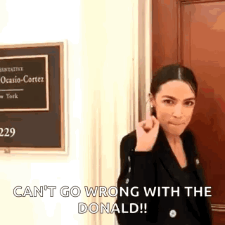 A Woman Is Standing In Front Of A Door With A Sign That Says `` Can T Go Wrong With The Donald '' . GIF