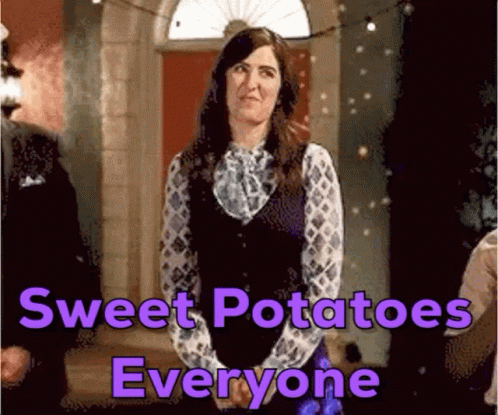 A Woman Is Standing In Front Of A Door With A Sign That Says Sweet Potatoes Everyone GIF