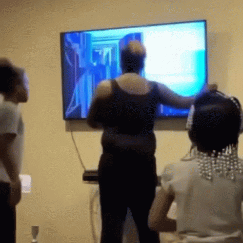 A Woman Is Standing In Front Of A Flat Screen Television While Two Children Watch . GIF