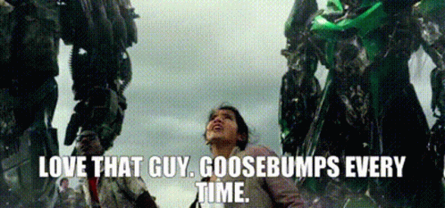 A Woman Is Standing In Front Of A Giant Robot And Says `` Love That Guy Goosebumps Every Time '' . GIF