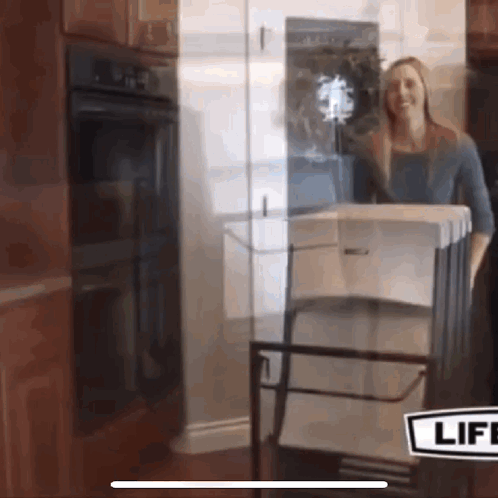 A Woman Is Standing In Front Of A Glass Door With A Sign That Says Life GIF