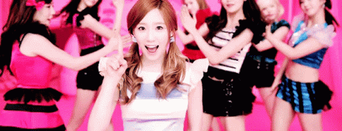 A Woman Is Standing In Front Of A Group Of Dancers . GIF