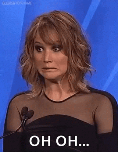 A Woman Is Standing In Front Of A Microphone And Making A Face . GIF
