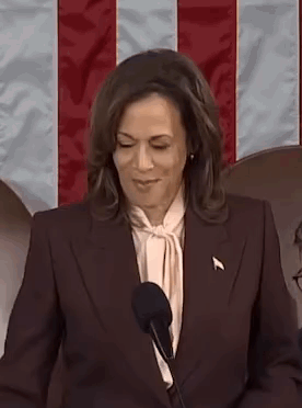 A Woman Is Standing In Front Of A Microphone And Smiling . GIF