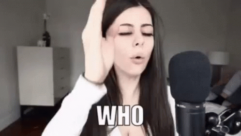 A Woman Is Standing In Front Of A Microphone With Her Eyes Closed And Making A Funny Face . GIF