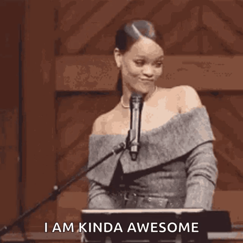 A Woman Is Standing In Front Of A Microphone With The Words `` I Am Kinda Awesome '' Written Below Her . GIF